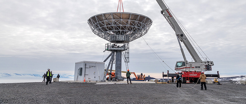 A crane carefully places the Ross Island Earth Station antenna reflector onto its pedestal